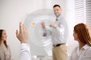 Young man raising hand to ask question at training in conference room, closeup