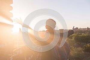 Young man raising hands up against sunlight - indicated success, achievement and victory. photo