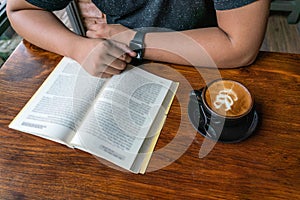 Young man read a book and drink coffee