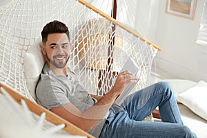 Young man reading book in hammock