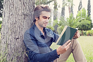 Young man reading book in park