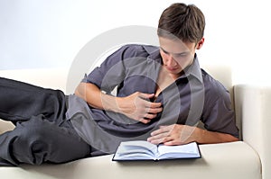 Young man reading book on the sofa