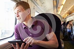 Young Man Reading A Book On Train Journey