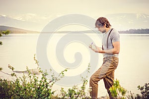 Young Man reading book and writing notes outdoor