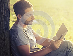 Young man reading e-book