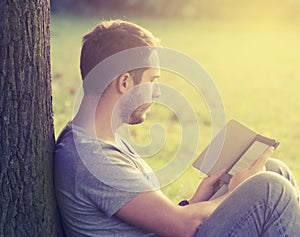 Young man reading e-book