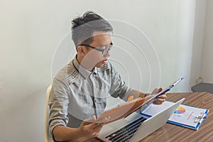 Young man reading financial report at workplace