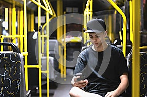 Young man reading a message in a public transport