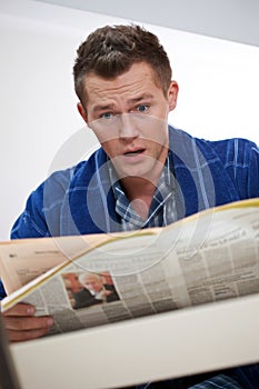 Young man reading newspapper photo