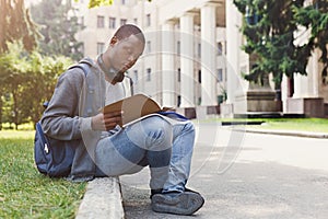 Young man reading notes at university copy space