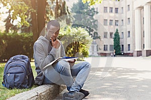 Young man reading notes at university copy space