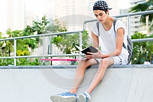 Young man reading at the skateboard park.