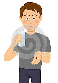 Young man is ready to take pills holding a glass of water photo