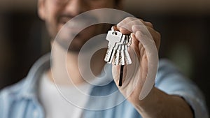 Young man realty buyer or seller holding keys in hand