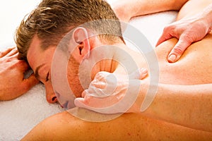 Young man receives massages to the shoulders