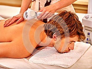 Young man receiving electric facial massage. photo
