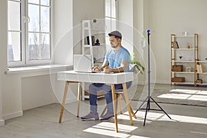 Young man receiving intravenous vitamin therapy while working with laptop at his workplace