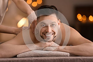 Young man receiving massage at spa salon