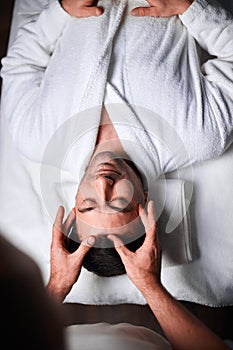 Young man receiving massage at spa salon, top view