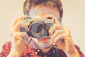 Young man is taking a picture with a vintage camera