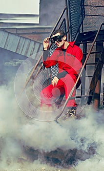Young man in red overall in industrial style