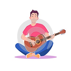 Young man in red T-shirt and sneakers sitting and playing acoustic guitar.