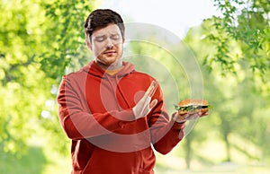 Young man refusing from hamburger