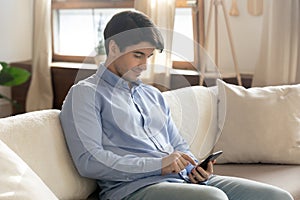 Young man relax on couch using smartphone