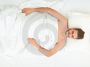 Young man relaxation on the bed top view