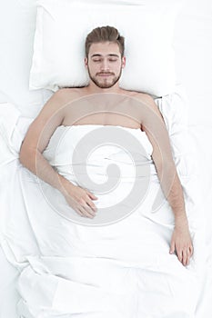 Young man relaxation on the bed top view