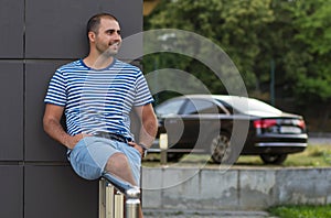 Young man relaxing with car background