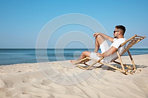 Young man relaxing in deck chair