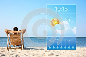 Young man relaxing in deck chair on beach and weather forecast widget. Mobile application