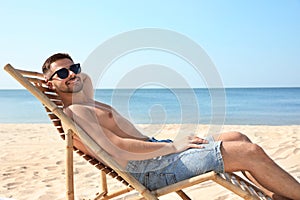 Young man relaxing in deck  on sandy beach