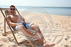 Young man relaxing in deck  on sandy beach