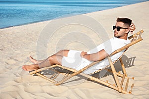 Young man relaxing in deck  on sandy beach