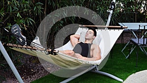 Young man relaxing on hammock in garden