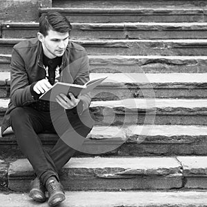 Young man relaxing and reading a book.