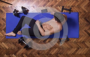 Young man relaxing smartphone elevated view exercise mat