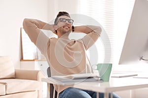 Young man relaxing at table in office