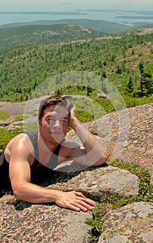 Young man relaxing on the top of the mountain