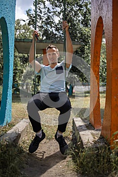 Young Man Reliving His Childhood Plying In A Children`s Playground