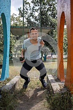 Young Man Reliving His Childhood Plying In A Children`s Playground