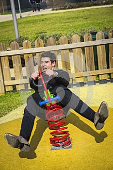 Young man reliving his childhood plying in a children's playground