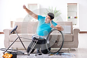 The young man repairing bicycle at home