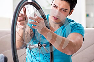 The young man repairing bicycle at home