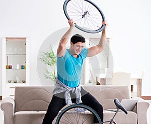 Young man repairing bicycle at home