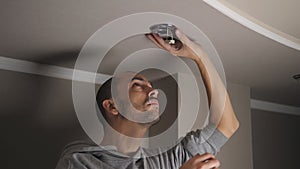 young man repairing cable wiring and installs or replaces the halogen lamp on the ceiling