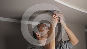 young man repairing cable wiring and installs or replaces the halogen lamp on the ceiling