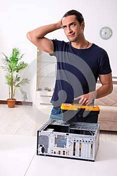 Young man repairing computer at home